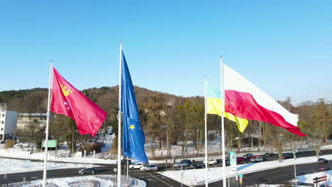 cámara lenta de banderas de ucrania, polonia, la ue y gdansk ondeando bajo el viento en astas de bandera