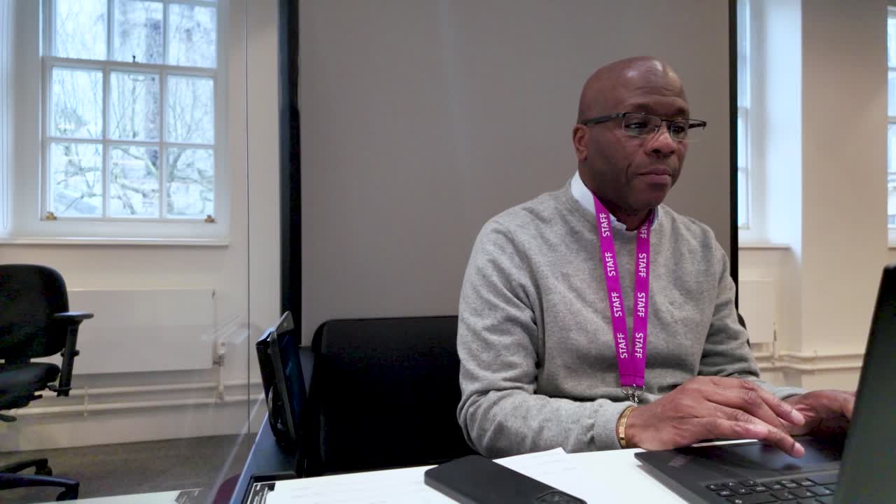 Man using a laptop in an office with focused ambiance and modern elements.