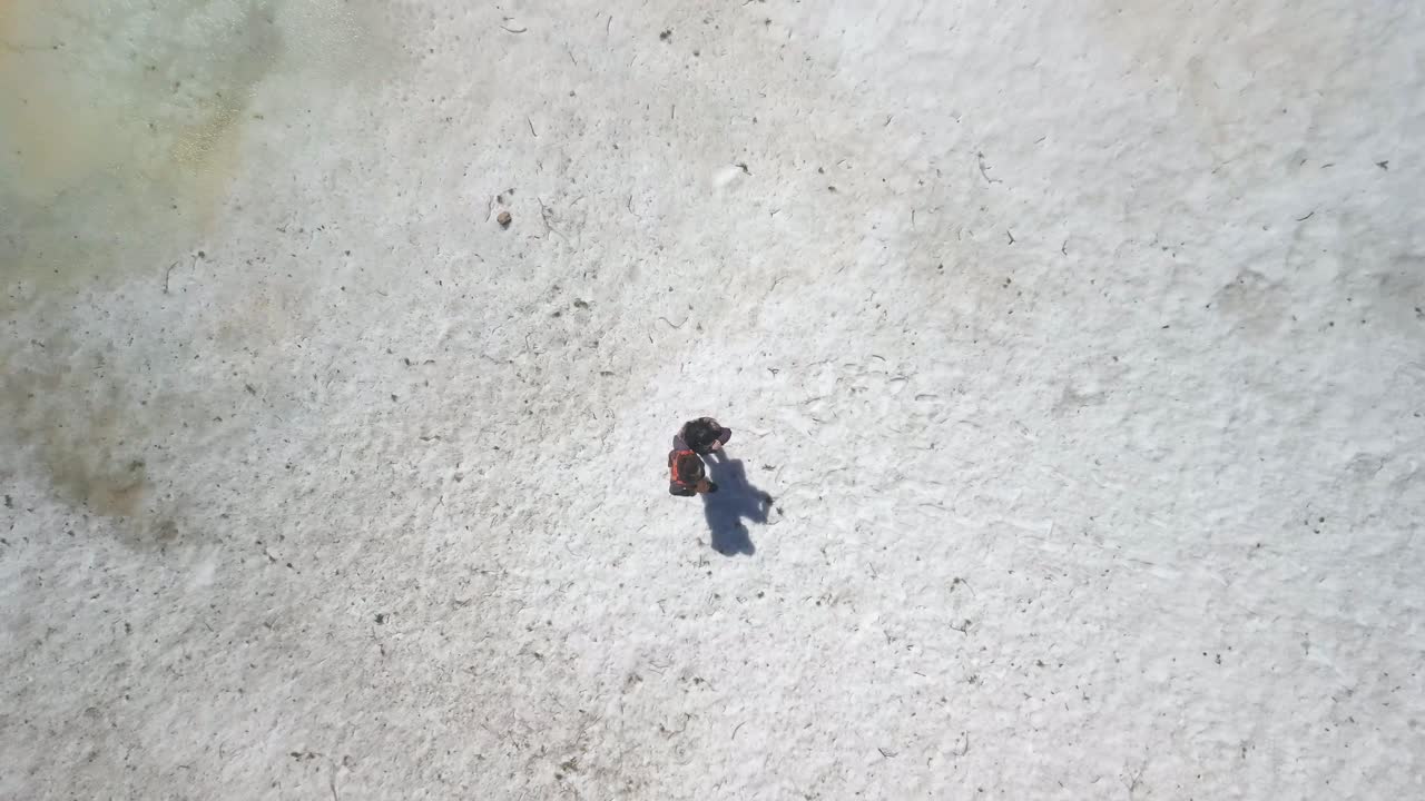 얼어붙은 호수를 따라 눈 속을 걷고 있는 부부의 조감도