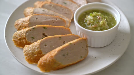 fried chinese fish cake or fish ball line sliced with spicy seafood dipping sauce