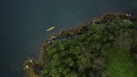 Toma-Aérea-De-Drones-De-Kayakistas-En-Un-Enorme-Lago-Con-Costa