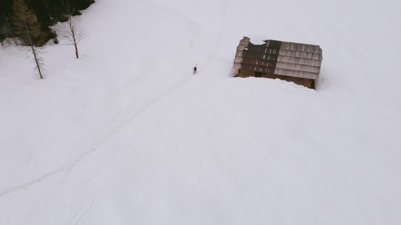 paisaje nevado de invierno con coníferas y casa de madera solitaria en krnica, kranjska gora, eslovenia - toma aérea de drones