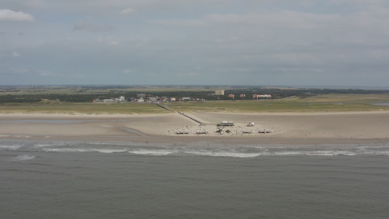 Drone - Aerial panorama circling shot of the sandy beach with tourists and people in St. Peter Ording at the north sea, schleswig holstein, germany, 30p