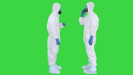 doctors or scientists in hazamat suits meet and shake hands on a green screen, chroma key