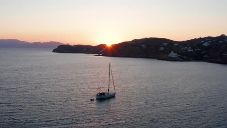 Vista-Aérea-Del-Barco-Durante-La-Puesta-De-Sol-En-Mylopotas-Beach-Ios-Grecia