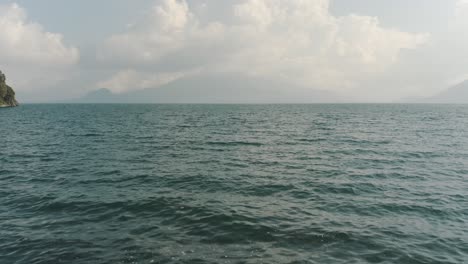 Drone-Aéreo,-Volando-Bajo-Desde-El-Muelle-En-El-Lago-De-Atitlán,-Guatemala