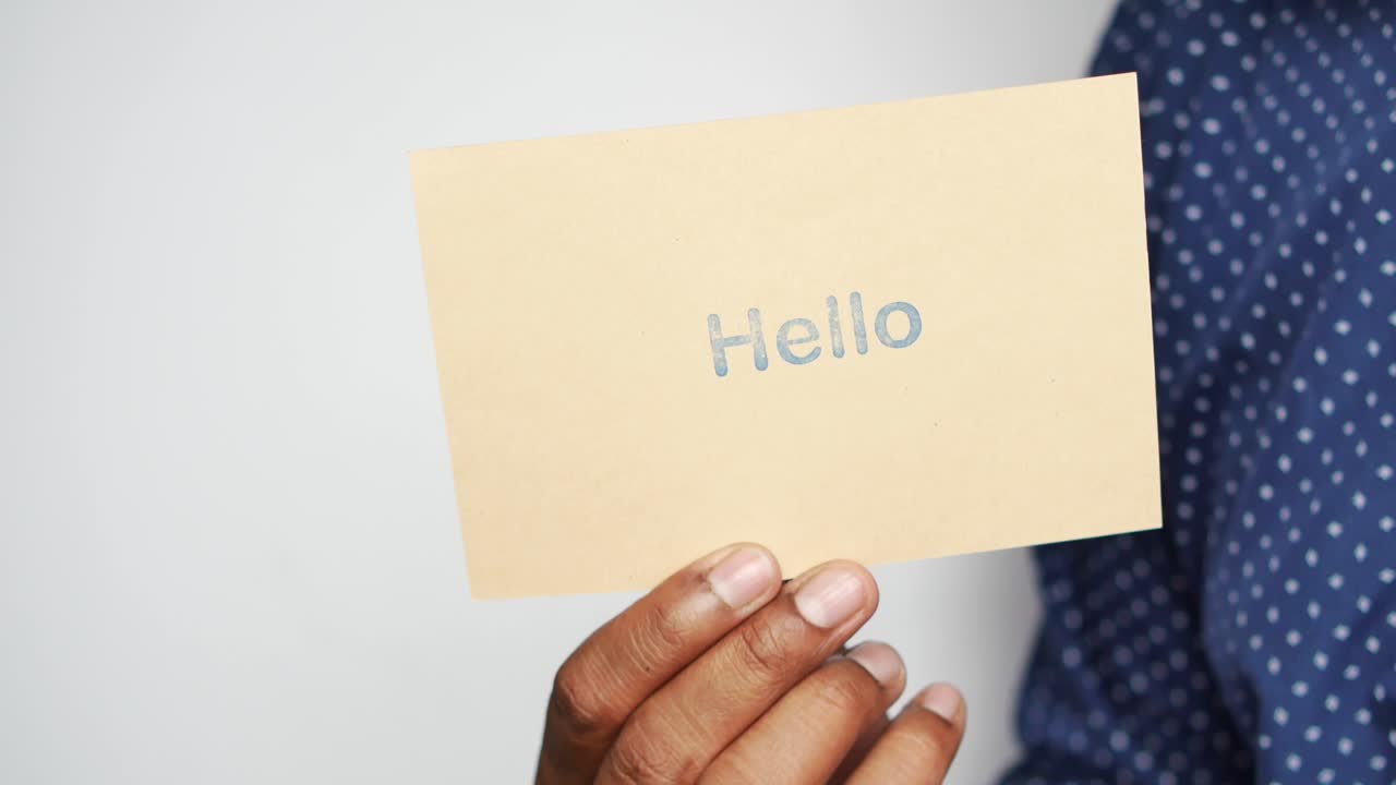 Holding a hello text in blue  on a paper ,