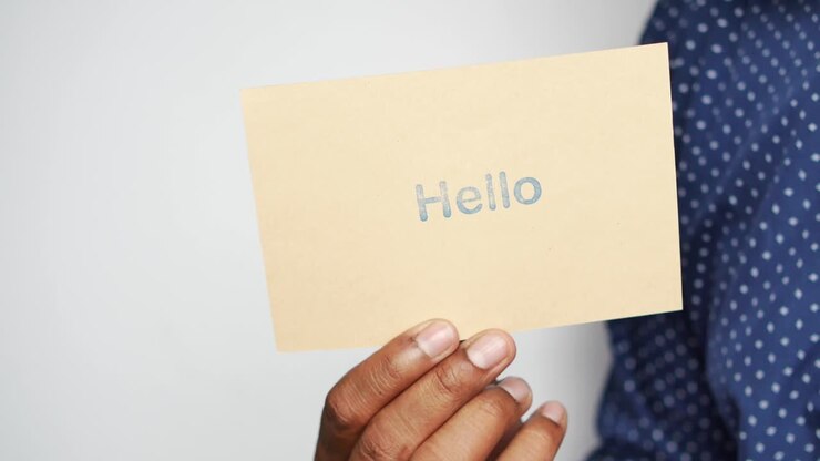 Holding a hello text in blue on a paper ,
