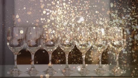 Animation-of-gold-lights-over-empty-wine-glasses
