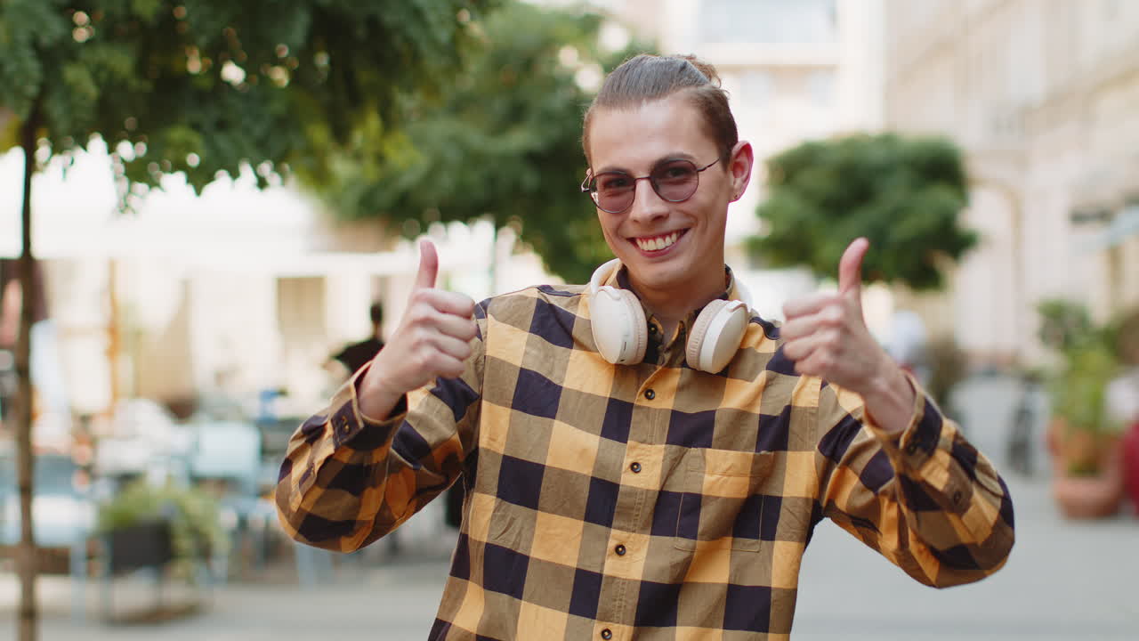 Happy man tourist showing thumbs up like sign gesture good positive feedback on urban city street