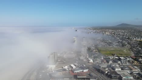 ciudad costera cubierta por una espesa niebla proveniente del océano
