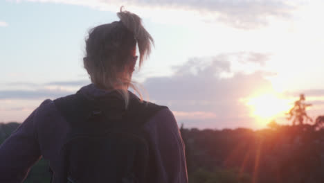 Female-walks-through-natural-landscape-in-the-sunset