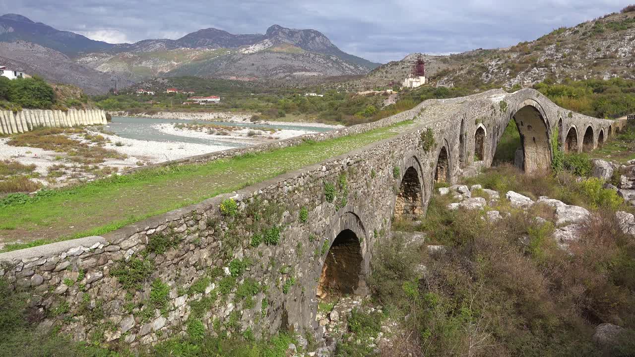 un viejo puente de piedra cruza un río en albania