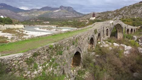 an old stone bridge crosses a river in albania