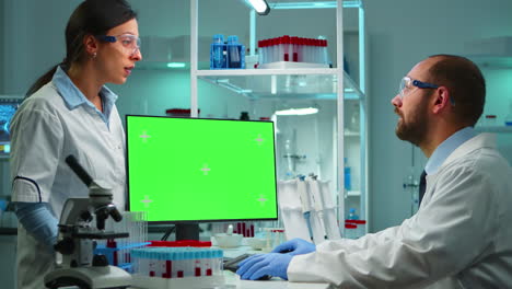 doctor working at computer with green screen over time