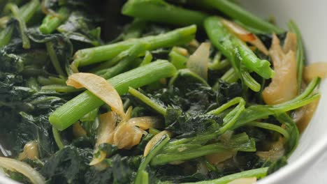 Top-view-of-bowl-with-cooked-spinach-on-table