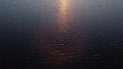 sunbeams reflecting on the lake surface and revealing a beautiful sunset