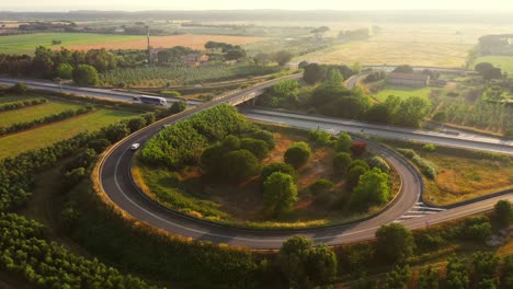 aerial drone footage: long haul semi truck driving on the busy highway in the rural region of italy. beautiful scenery of nature and human logistics progress