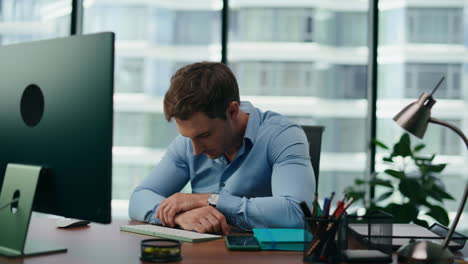 portrait depressed office manager shocked by business failure sitting at desk.