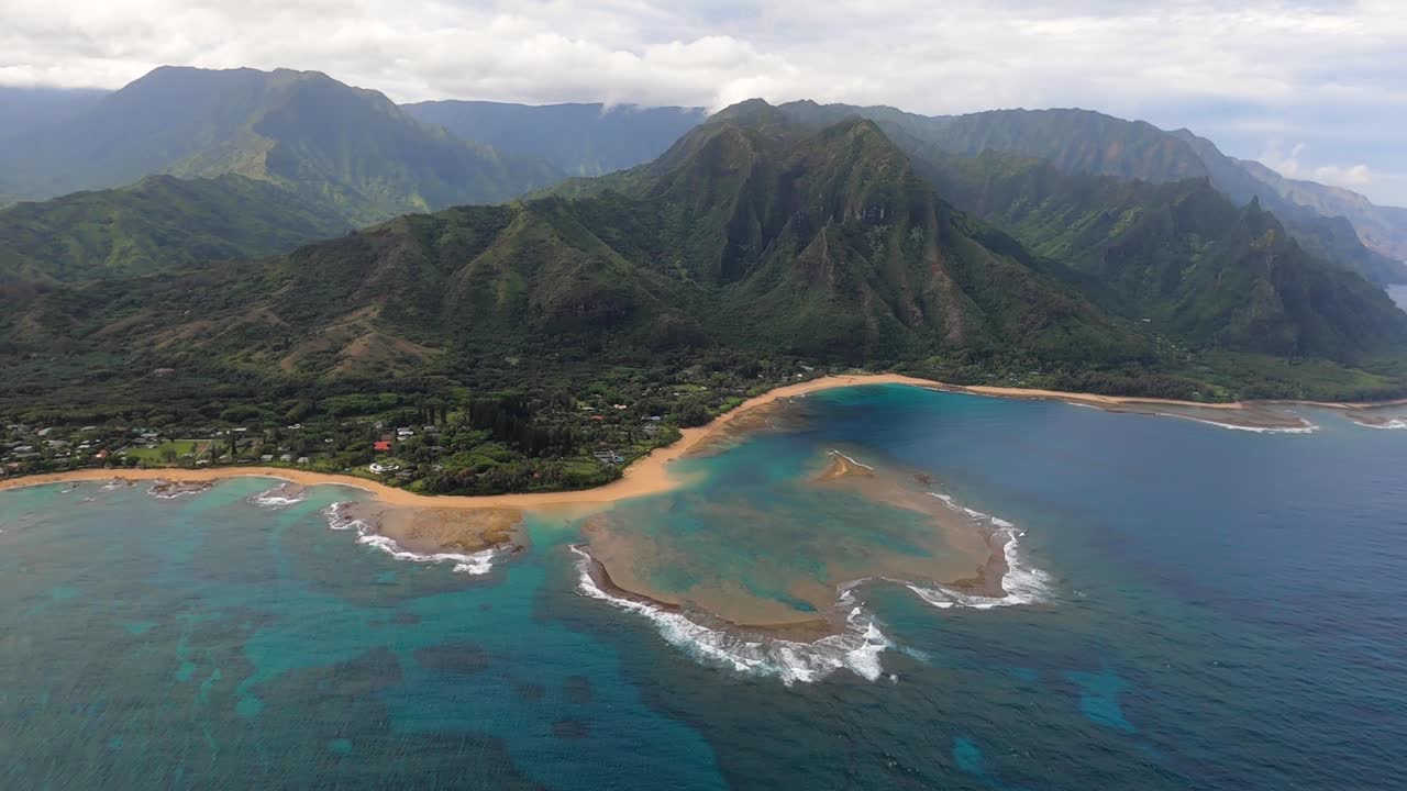 impresionante toma aérea a lo largo de la costa de los túneles playa en la isla hawaiana de kauai con las montañas de na pali
