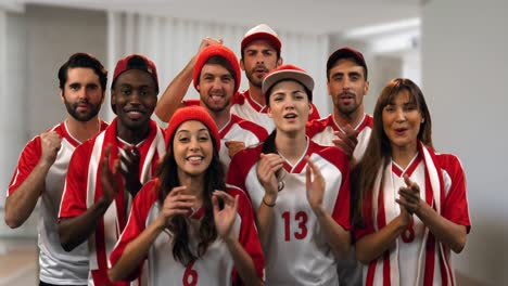 group of male and female sports fans cheering and clapping in slow motion