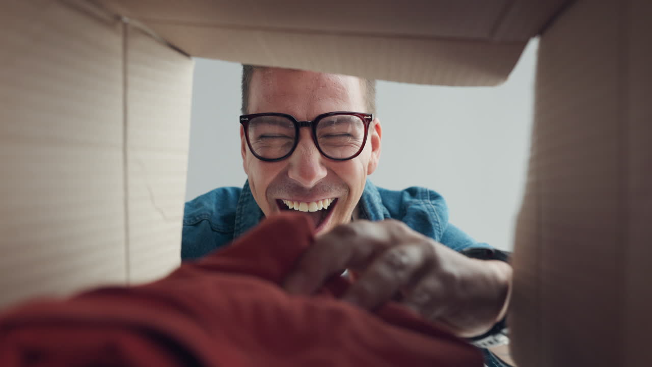 기쁜 마음으로 선물을 박스 밖으로 내보내는 남자