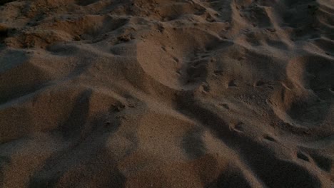 Rotating-Wide-angle-beach-sand-scene-shot-at-sunset-consisting-of-sand,-gravel,-shingle,-pebbles,-beachside-no-stress-tranquilty-peace-moody-contrast-golden-light-cavities