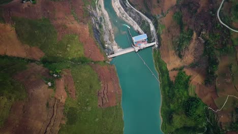 directamente sobre un embalse y una presa de color turquesa