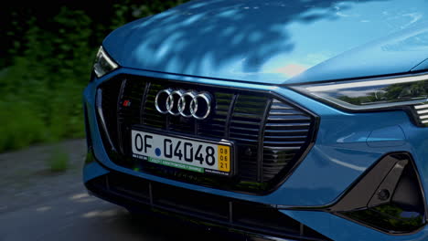 audi logo of e-tron car. electronic car moving on a road. front view of a luxury sport car model. element of expensive automobile. close-up.