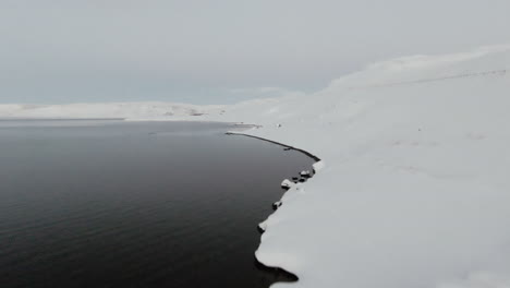 fpv above white snowy ocean coast with full moon on sky in background