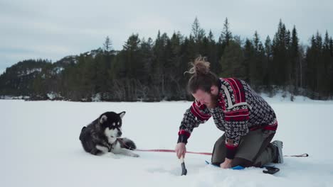 bearded norwegian guy is breaking frozen lake using a handy wood axe