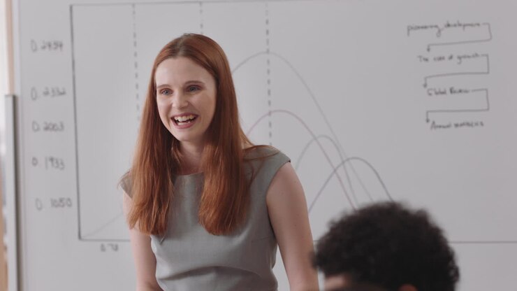 red head business woman team leader meeting with colleagues sharing creative ideas for startup project discussing corporate strategy in office boardroom