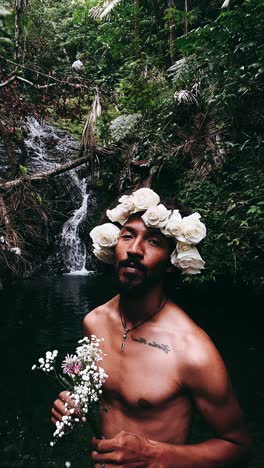 man with flower crown in a waterfall forest