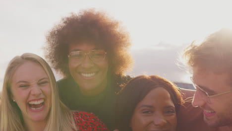 group of university or college students outdoors on campus smiling and looking at camera