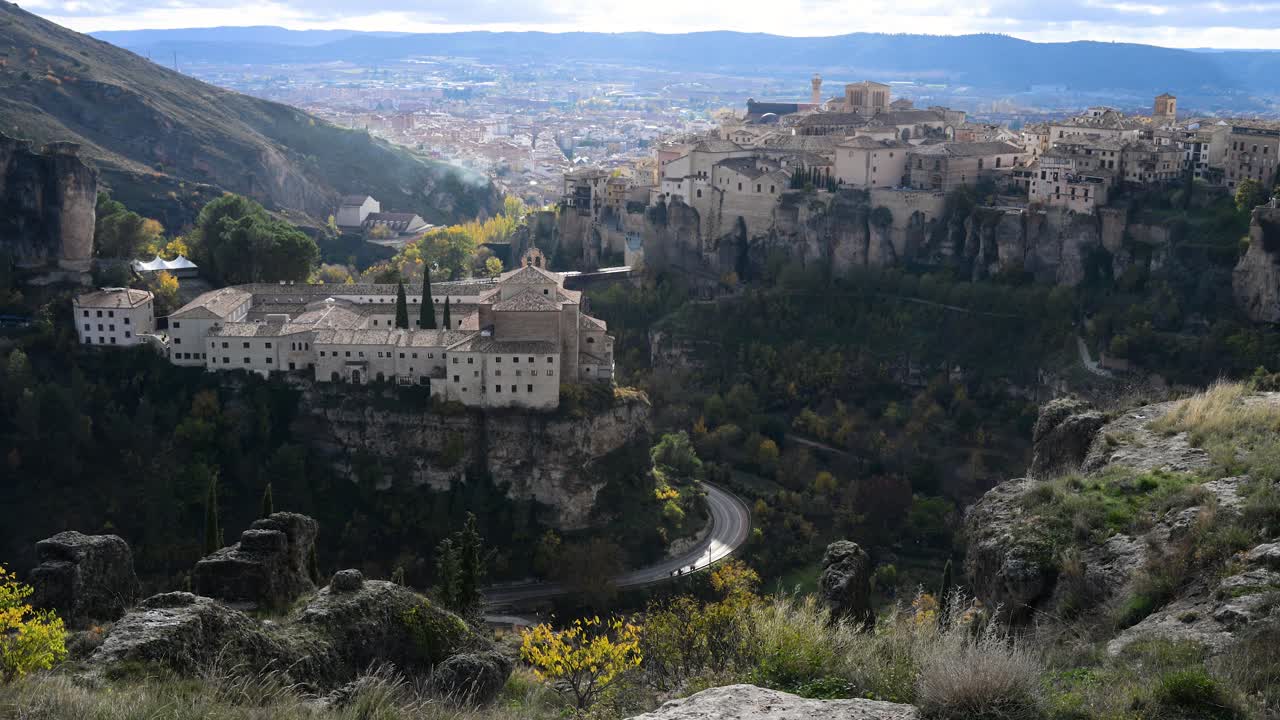 A panoramic vista in Cuenca, Spain, contrasts the sacred history of the Convent of San Pablo with the iconic domestic architecture of the Hanging Houses.