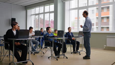 classroom scene with students and teacher using computers