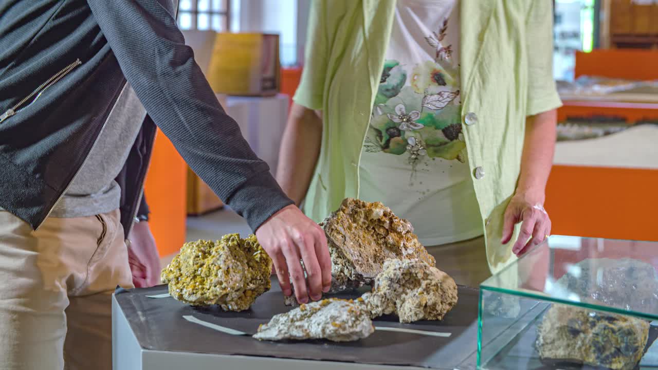 Museum guide show young man mineral rocks on display. close up