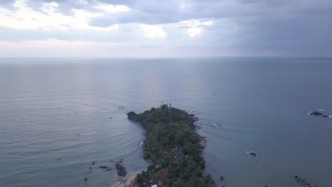 denso bosque en la isla rodeada por el sereno océano azul de la playa de rajbaga, canacona en el sur de goa, india