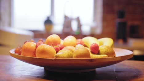 healthy fruit basket for breakfast in a sunny kitchen, filled with bananas, oranges, strawberries and grapes