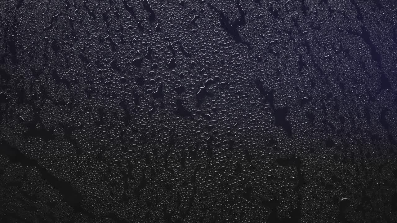 Close up of red and blue police lights reflecting on a wet surface covered in water droplets. Crime scene or emergency texture background