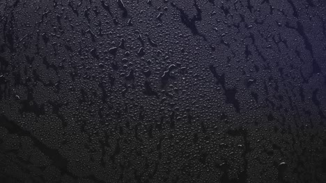 Close up of red and blue police lights reflecting on a wet surface covered in water droplets. Crime scene or emergency texture background