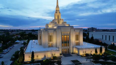 LDS-Mormon-Temple-in-Ogden-Utah-drone-flight-flying-at-dusk-on-beautiful-summer-night-panning-up-and-out-looking-at-religious-building-face-to-reveal-Angel-Moroni-on-spire-at-top-of-building