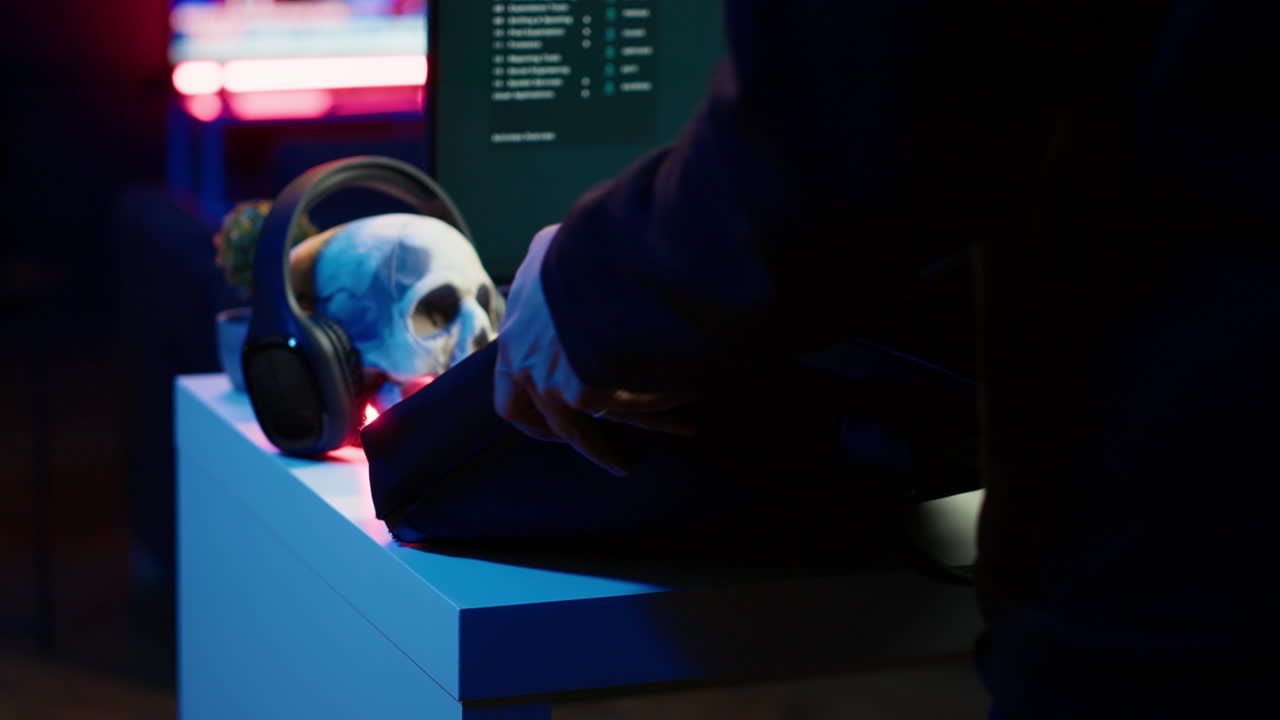 el cibercriminal saca el cuaderno de la bolsa, comienza a trabajar en el guión de malware