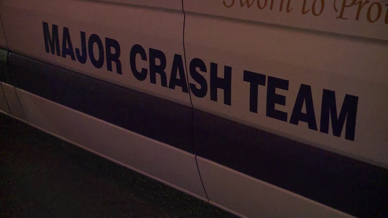 CLOSE UP OF SIGN OF MAJOR CRASH TEAM VAN WITH POLICE LIGHTS REFLECTING