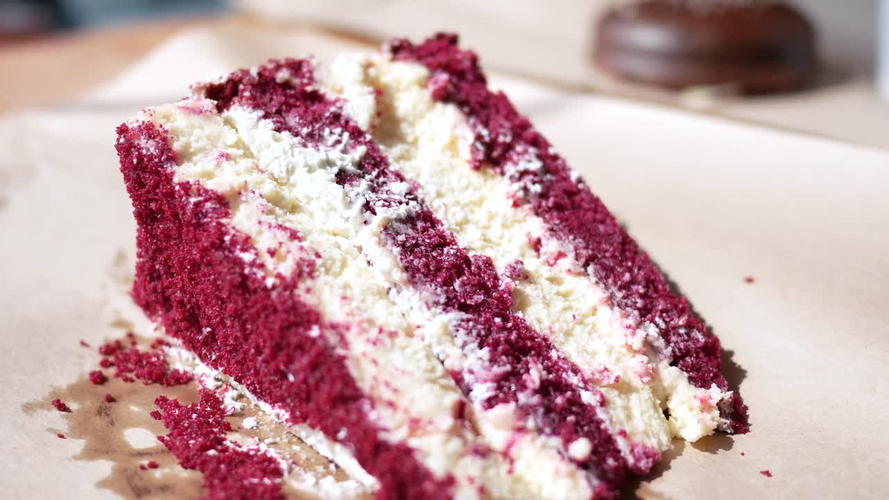 nahaufnahme eines stückes roter samtkuchen mit weißem glasur