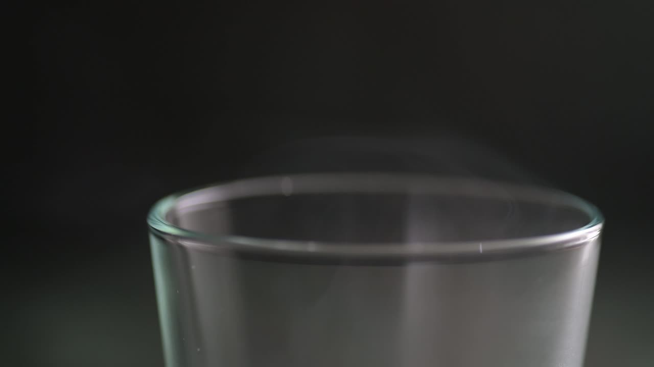 뜨거운 음료를 담은 증기 유리잔의 가장자리의 클로즈업 매크로