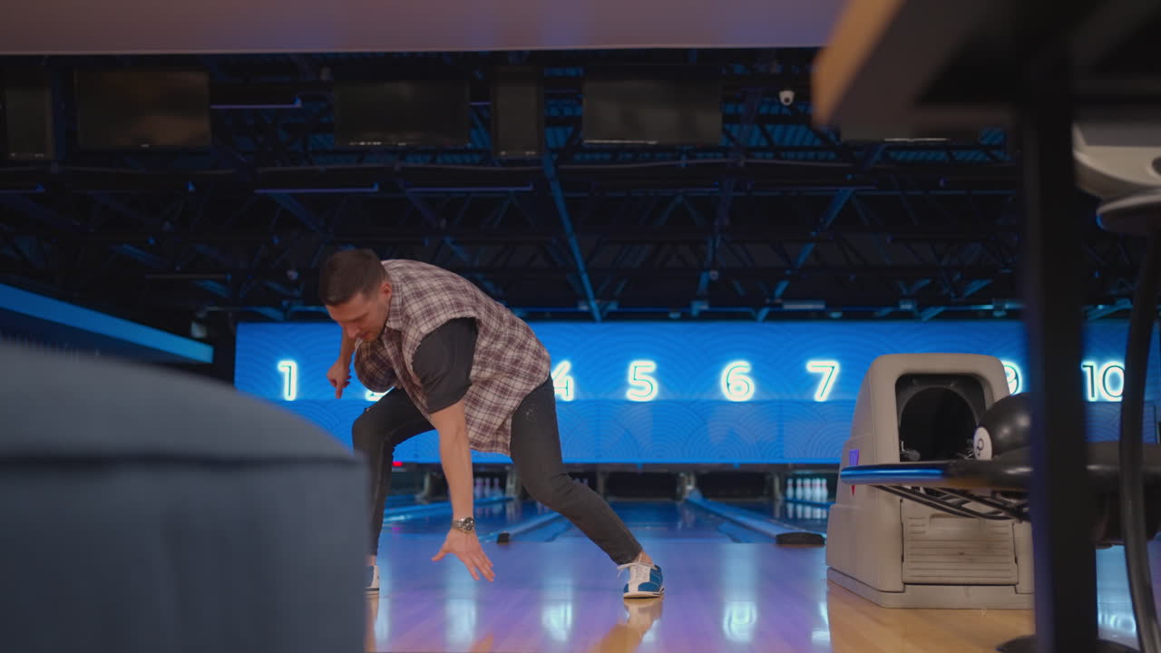 A man dances a victory dance in a bowling club. Celebrating by doing a somersault