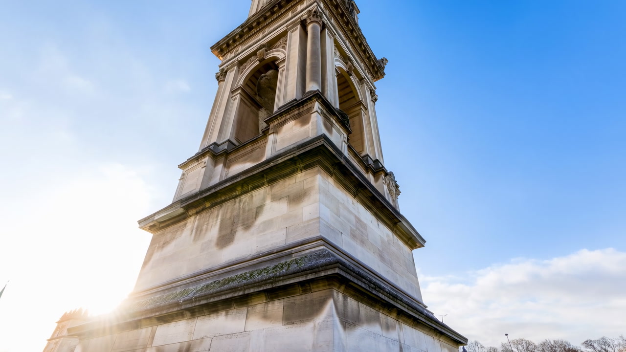 Sunlit Historic Monument Tower Low Angle Viewpoint Showing Detailed Stone Masonry, Classical Columns, Bright