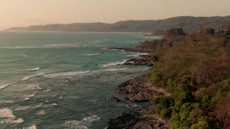 Inclinación-Aérea-Revela-Toma-De-Olas-Rompiendo-En-La-Costa-Rocosa-De-La-Selva-De-Costa-Rica