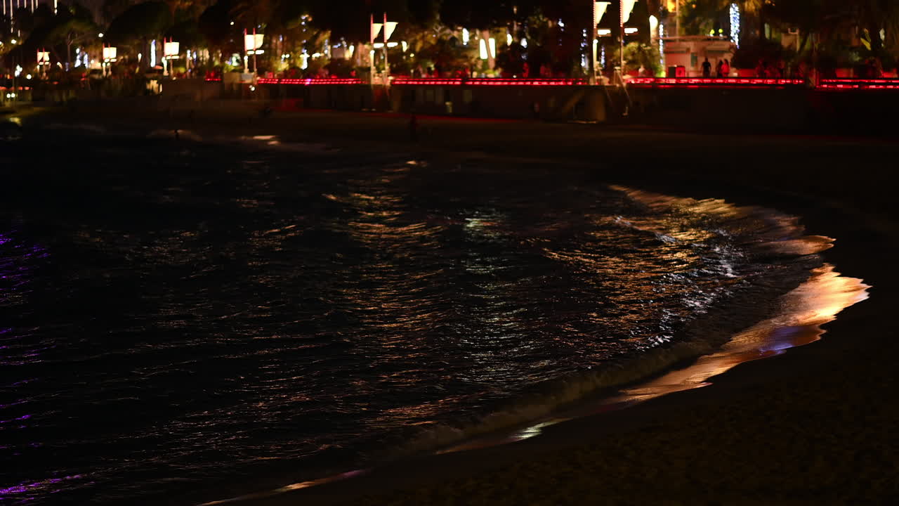 Sea waves at night with reflections in Cannes, France